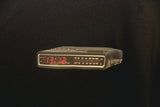Detailaufnahme Radiowecker-Print 13:12 auf schwarzem GKBS T-Shirt, rote LED-Anzeige, Good Kids Bad Society Schriftzug