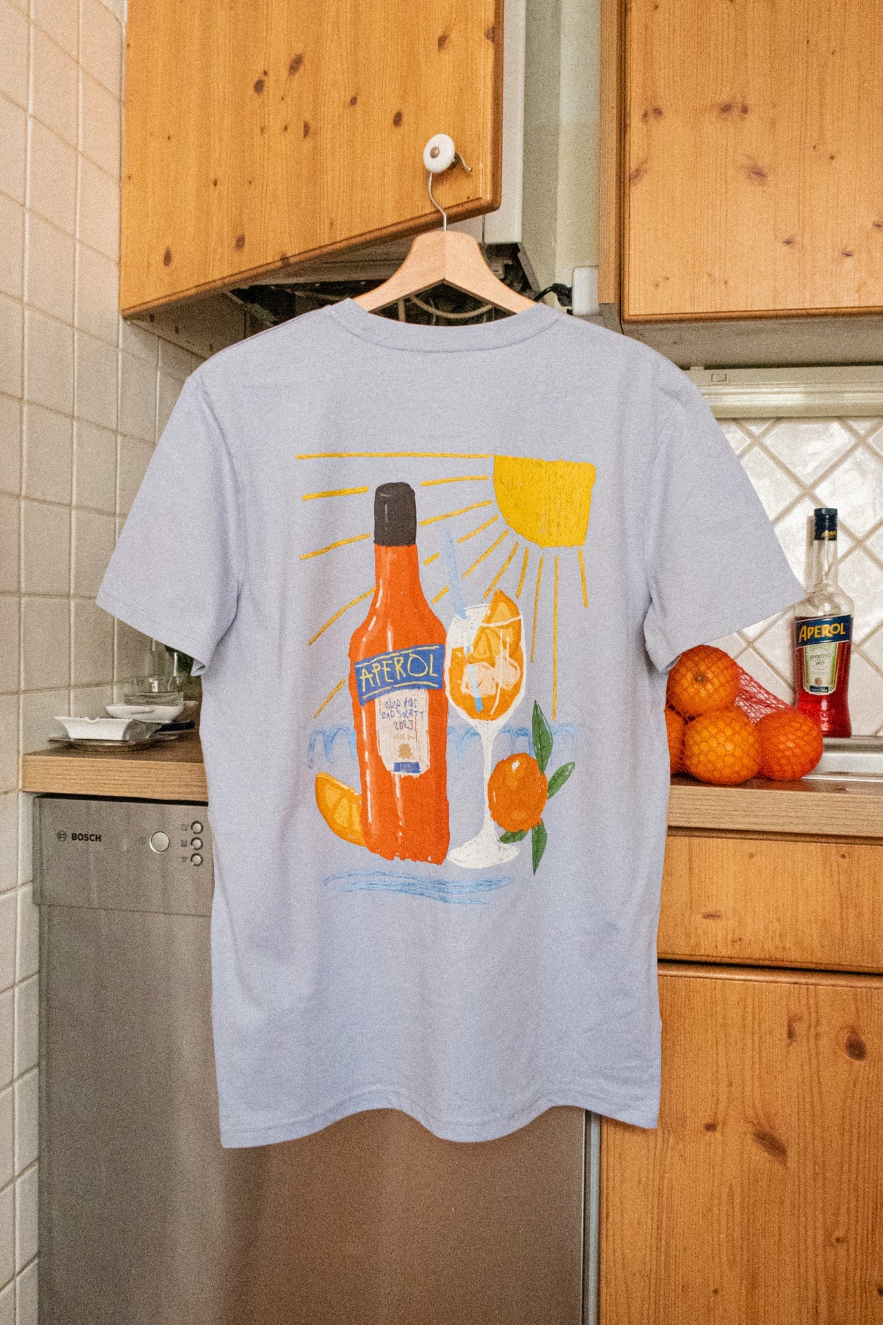 Wien Streetwear T-Shirt hellblau, Rückseite mit Aperol Spritz Illustration: Flasche, Glas und Sonne, DTF-Print