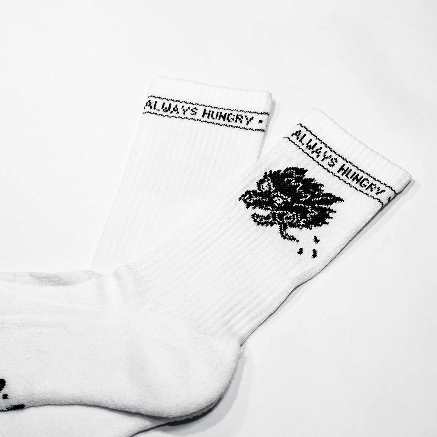 Always Hungry Socken Weiß von NKSP – Nahaufnahme des eingestrickten Wolfskopfs