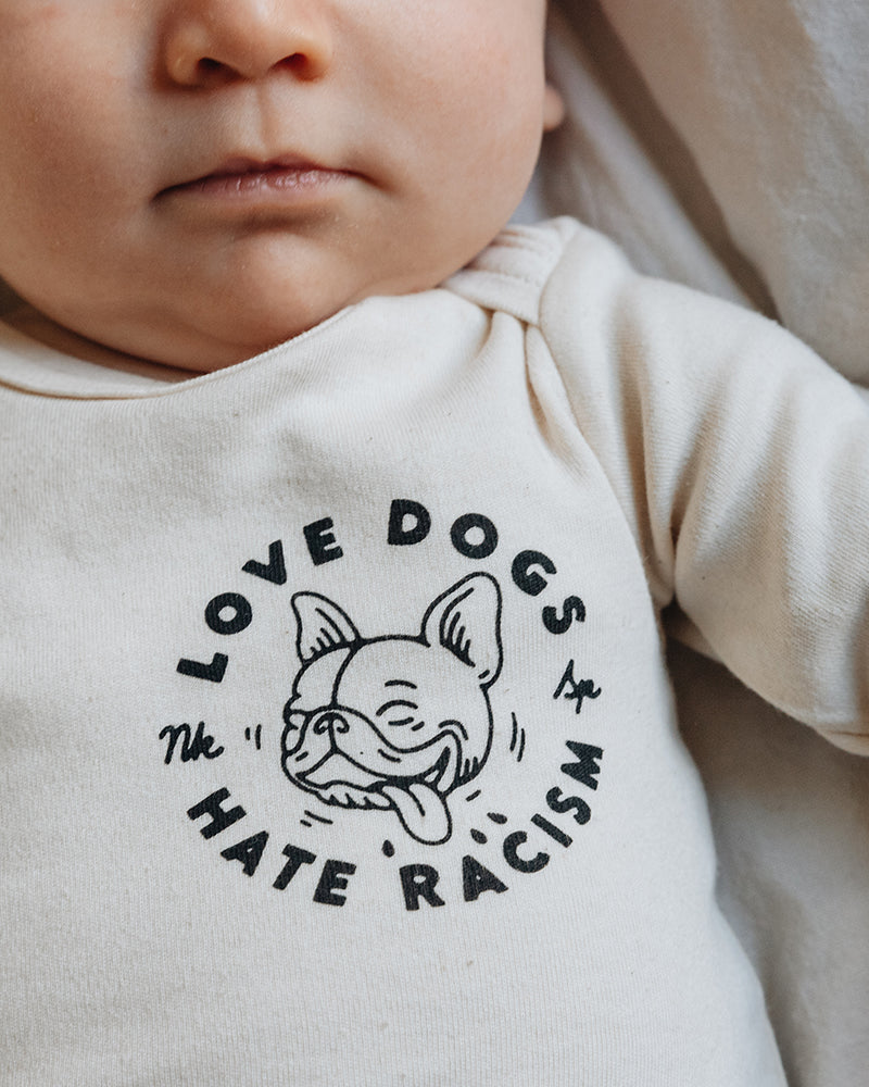 Love Dogs Hate Racism Baby Body Natur von NKSP – Print mit Hundegesicht