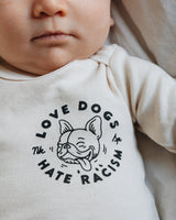 Love Dogs Hate Racism Baby Body Natur von NKSP – Print mit Hundegesicht
