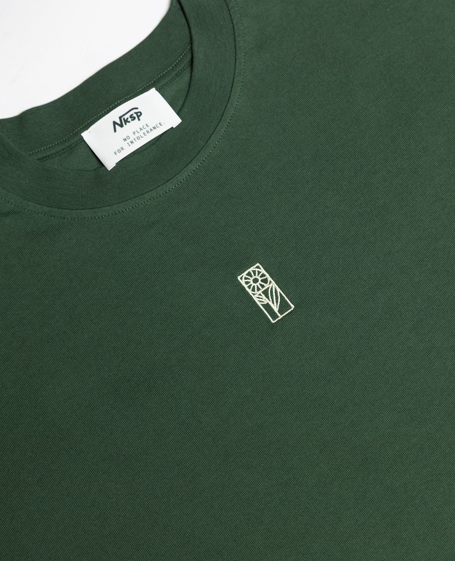 Blume Oversized T-Shirt Dunkelgrün von NKSP – Detail mit Stickerei und Nackenlabel