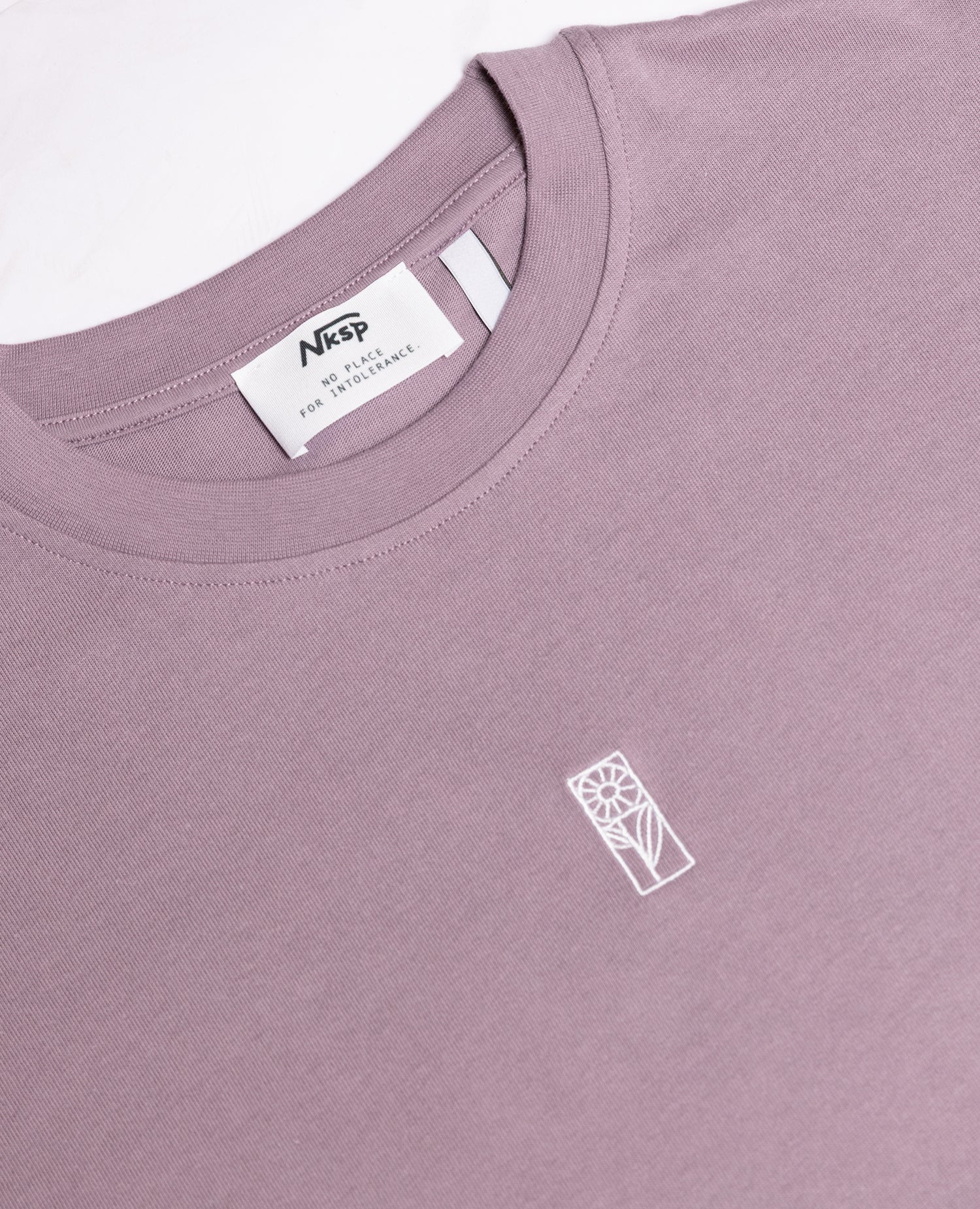 Blume Oversized T-Shirt Lila von NKSP – Detail mit Stickerei und Nackenlabel